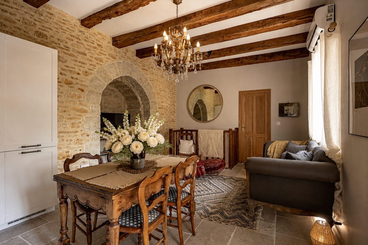 Beamed dining room with chandelier and old stone at Le Martin-Pêcheur
