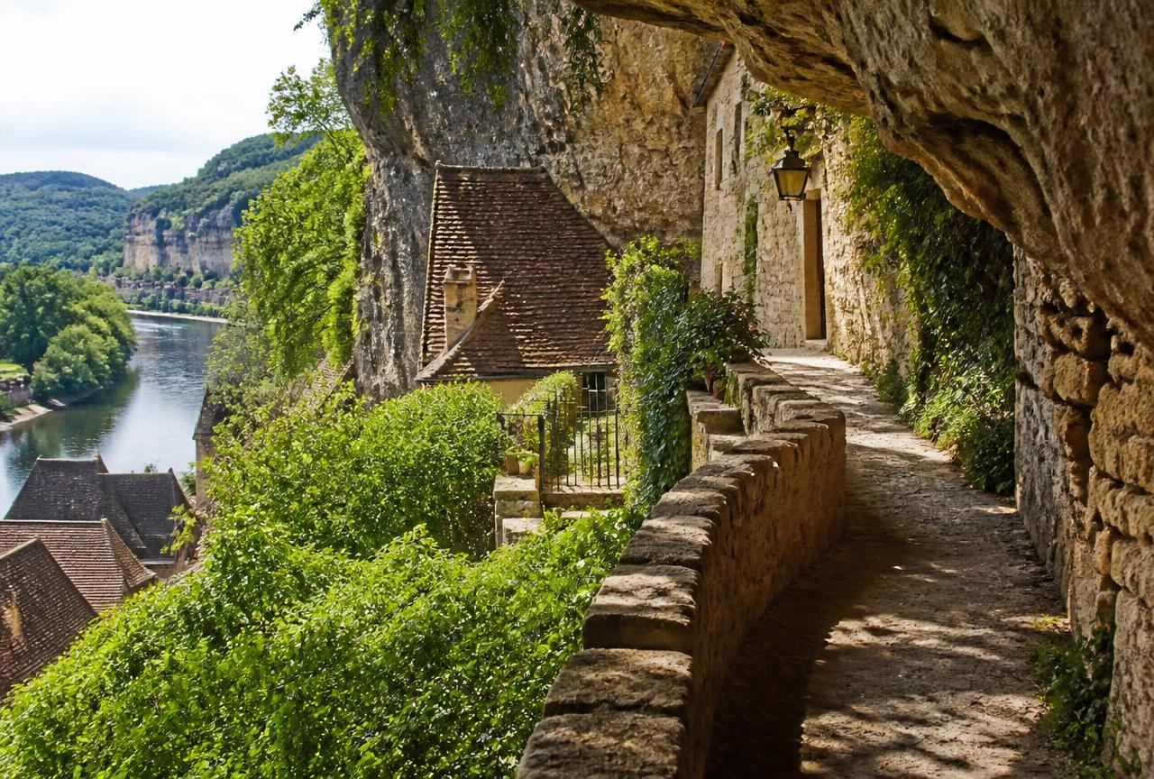 Stone footpath beneath the cliff past old houses in La Roque-Gageac